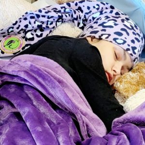 girl sleeping wearing purple cheetah nillynoggin eeg cap