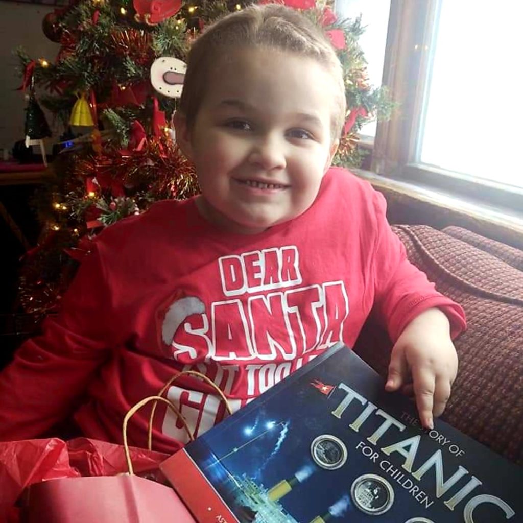 boy in red sweatshirt holding titanic book