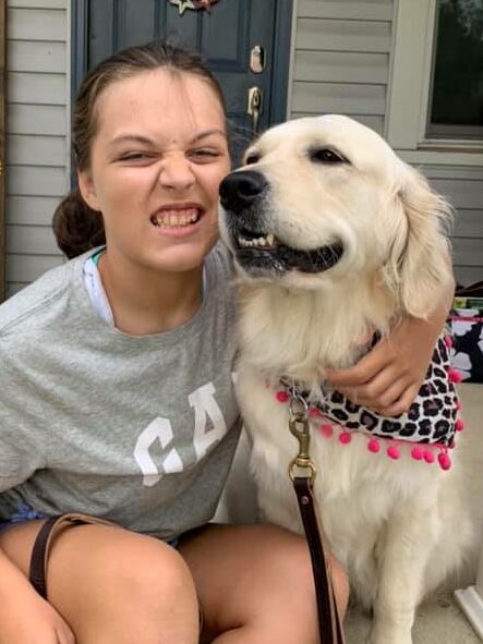 girl with dravet syndrome sitting on porch with seizure dog